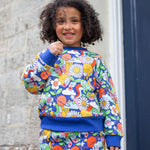 A child wearing the Frugi Easy On kids Jumper with a Retro Happy print with the matching trousers. 