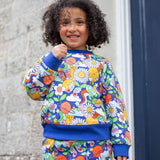 A child wearing the Frugi Easy On kids Jumper with a Retro Happy print with the matching trousers. 