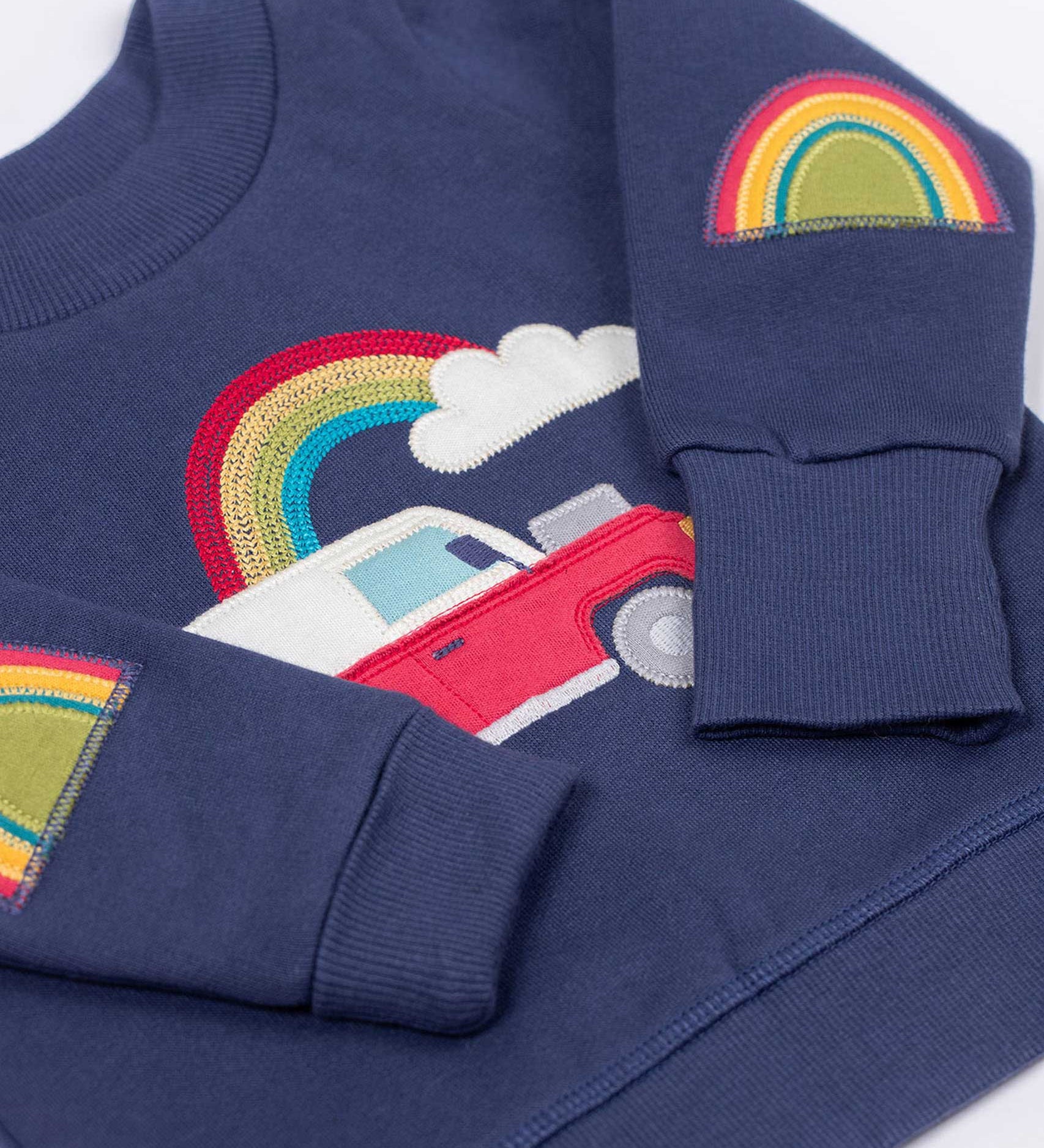 Frugi easy on organic cotton navy jumper with a red vehicle on the front and rainbow patch appliques on the elbows.