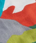 A super close view of the Frugi Elwood organic cotton knitted jumper with a blue mountain scene design showing the material.