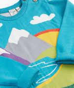 A close up of the front of the Frugi Elwood organic cotton knitted jumper with a blue mountain scene design.