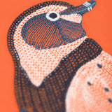 A close up of the Frugi kids embroidered adventure top in salamander/penguin showing the embroidery detail on pastel orange organic cotton fabric.
