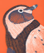A close up of the Frugi kids embroidered adventure top in salamander/penguin showing the embroidery detail on pastel orange organic cotton fabric.