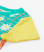 A close up of Frugi Estella Shirt's sleeve, with a Rainbow Hotchpotch print.
