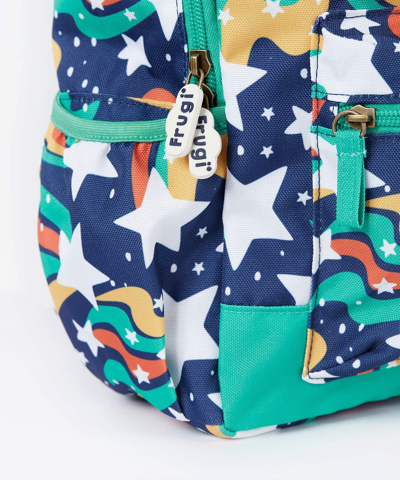 A close up of the Frugi magic stars explorer backpack showing the bottle holder, compartment zips and the playful outer space inspired print detail