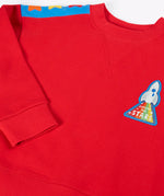 Close up of the rocket applique on the front of the Frugi Falmouth scarlet red sweatshirt.