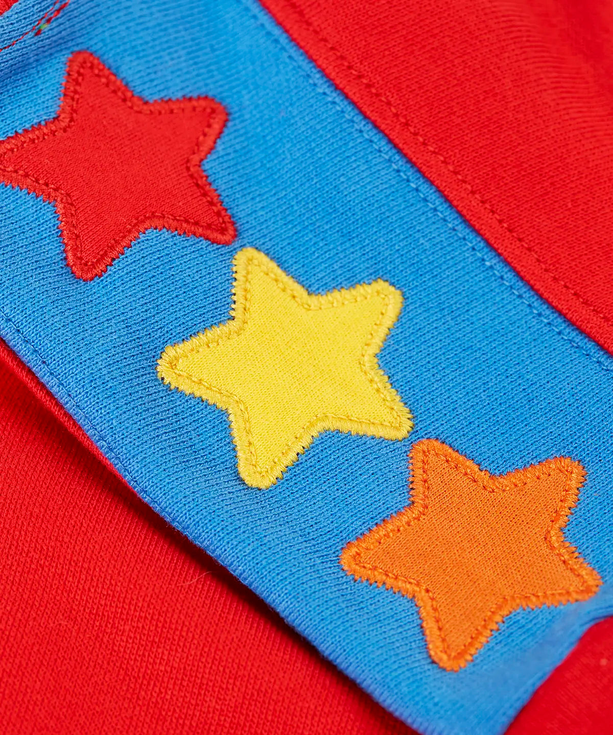 Close up of the three star appliques on the shoulders of the Frugi Falmouth scarlet red sweatshirt.