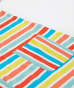 A close up of Frugi Faye Dress, showing the Sea Rainbow Stripe print and one of its front pockets.