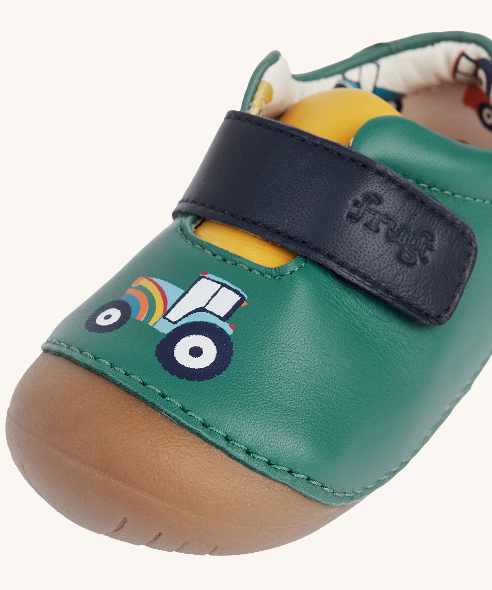 A close up of the tractor design on the front of the Fjord First Walker leather holly green baby shoes.
