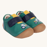 The Fjord First Walker leather baby shoes in a holly green colour have a tractor design on the front and a rainbow design on the back. The leather lining has a cream background with a colourful tractor print inside.