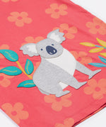 Close up of the Frugi kids flora fun koala t-shirt. Showing the appliqué of the grey koala next to coloured leaves on light pink organic cotton fabric with pastel orange floral prints