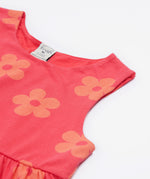 A close up of the Frugi kids summer flamingo / flower dress. Showing the detail neck and sleeve cuffs with the light coral flowers on pink organic cotton fabric
