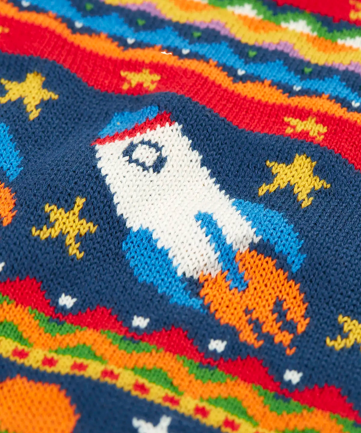 Close up of the details on the Frugi fowey Fairisle organic cotton knitted jumper with a space design featuring rockets, planets and stars. 