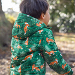 A child wearing the Frugi toasty trail reversible jacket showing the playful fox in woodland design and hood detail on green post consumer recycled polyester fabric
