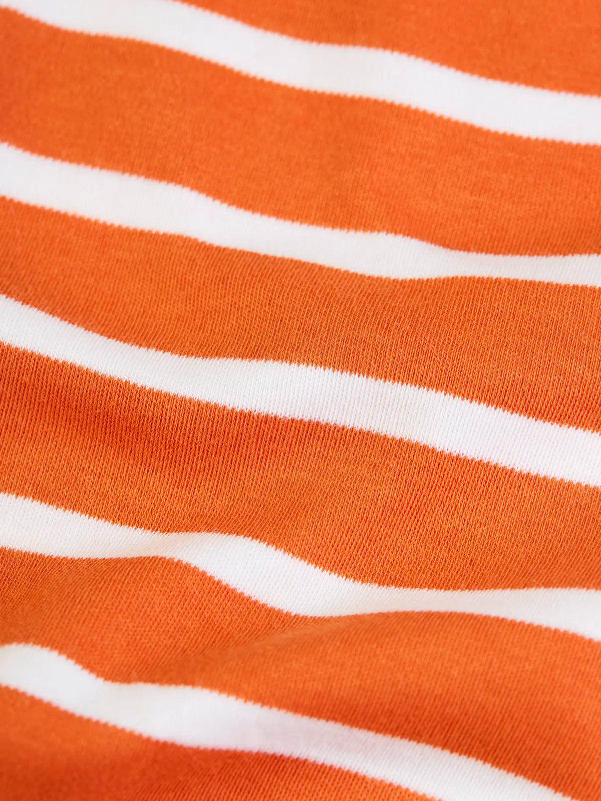 Close up of the wide orange stripe trousers from the Frugi frankie organic cotton baby and toddler outfit with Nessie design. 