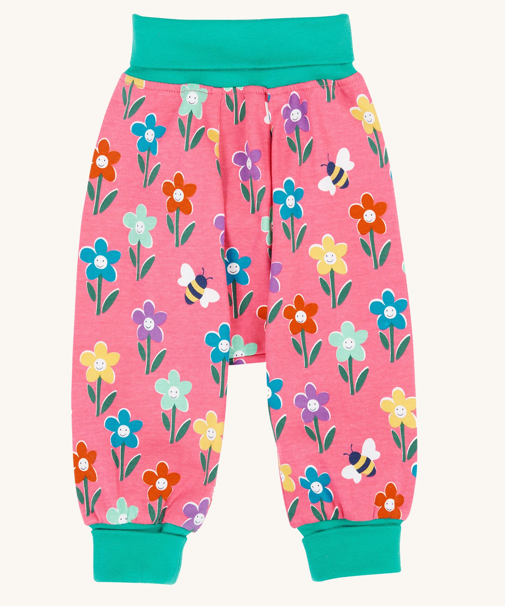 Frugi fun flowers print parsnip pants children's organic cotton trousers. The fun flowers print features multi-coloured flowers and bees on a pink background with turquoise coloured waistband and leg cuffs. 