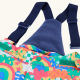 Frugi kids snow and ski salopettes in fun frenzy showing the removable navy shoulder strap and matching fleece back panel 