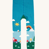 A view of the front of the Frugi organic cotton little knitted leggings with a fun guys red mushroom and farm design.