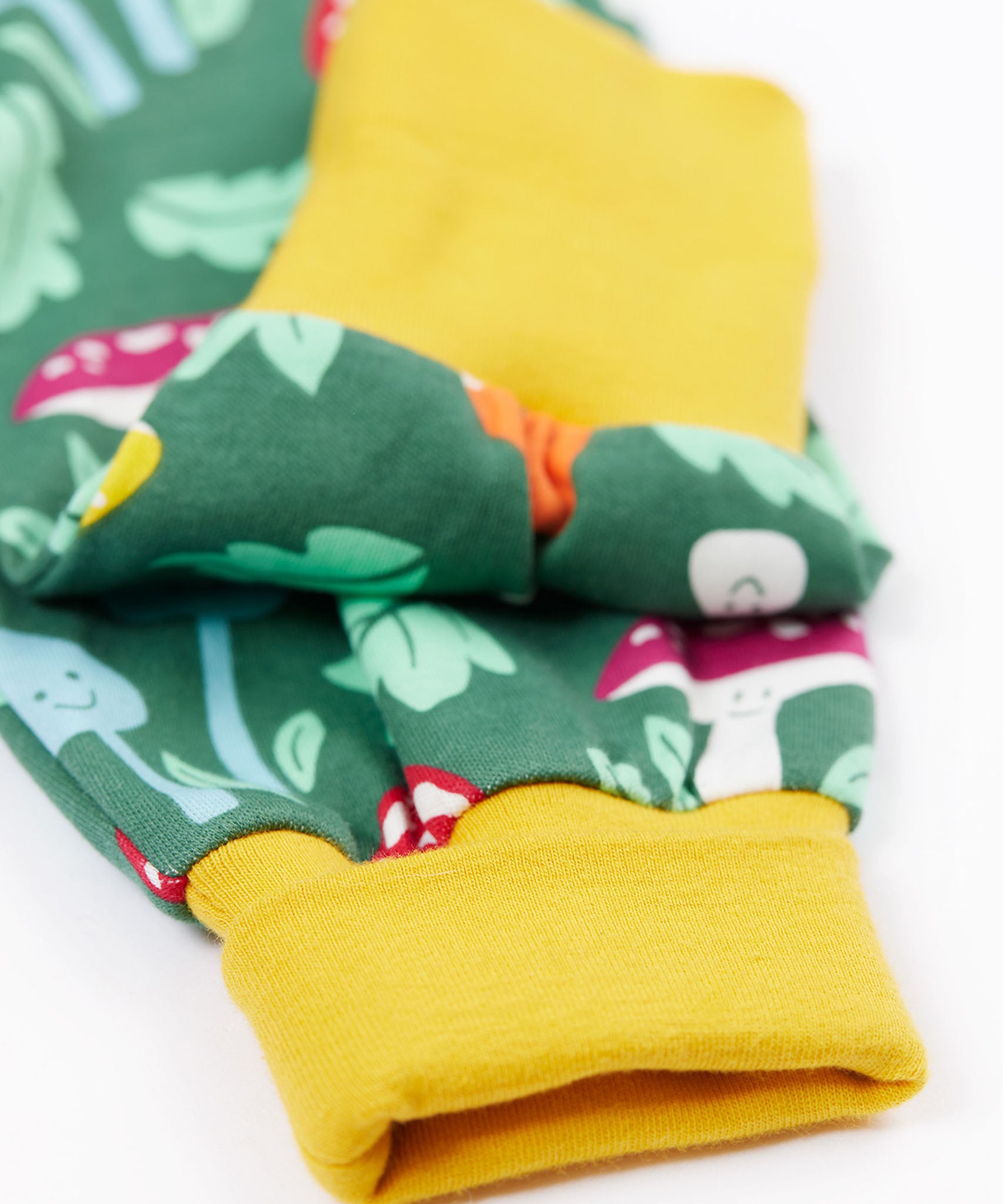 A close up of the yellow gold coloured cuffs of the Frugu fun guys mushroom design parsnip pants.