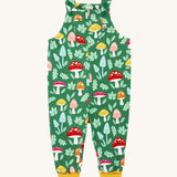 Frugi fun guys print dungarees. The Fun guys print features multi-coloured mushrooms and light green leaves on a dark green background. The dungarees have yellow gold coloured leg cuffs for extended wear.