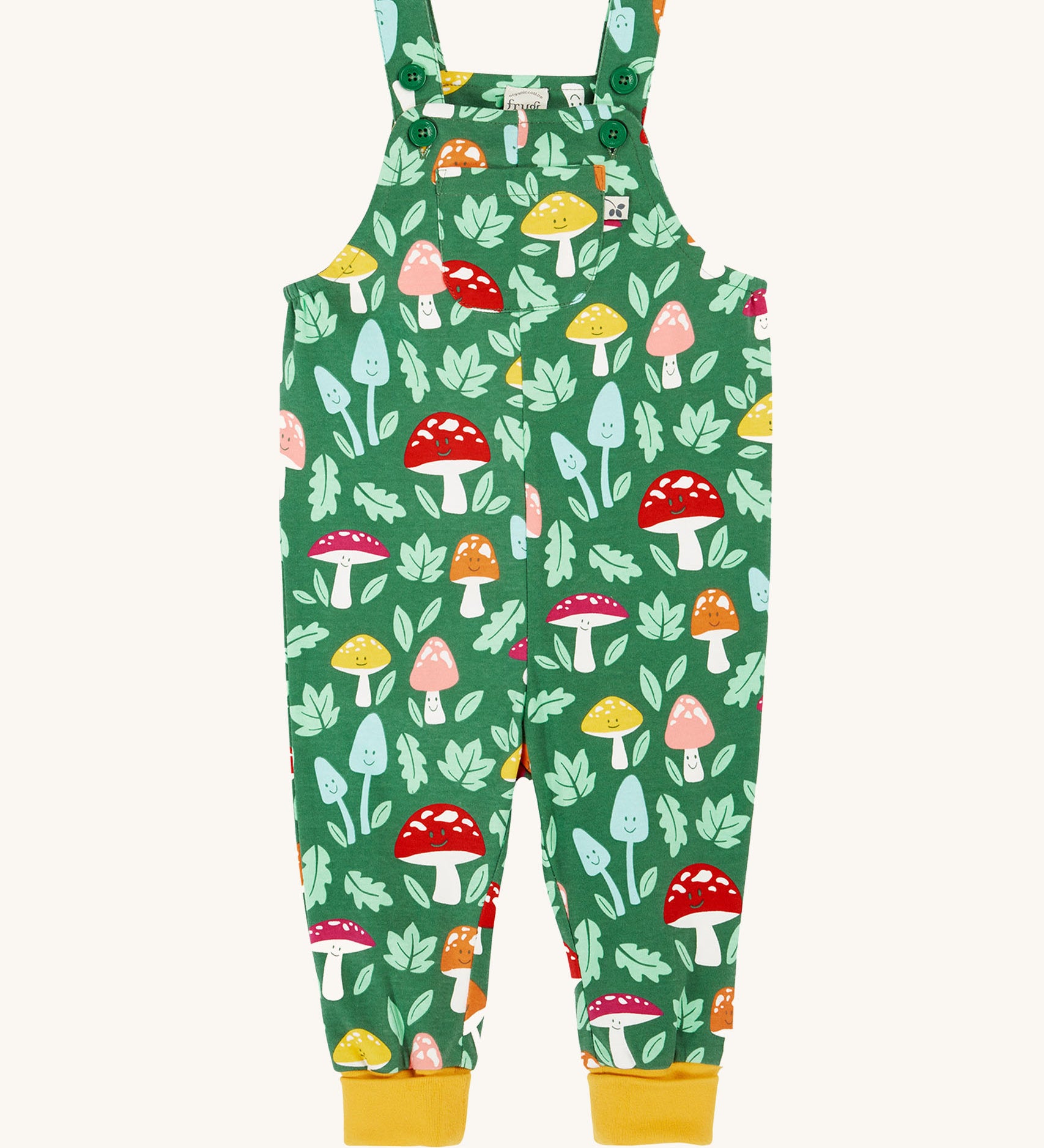 Frugi fun guys print dungarees. The Fun guys print features multi-coloured mushrooms and light green leaves on a dark green background. The dungarees have yellow gold coloured leg cuffs for extended wear.