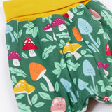 A close up of the mushroom themed print on the Frugi fun guys parsnip pants.