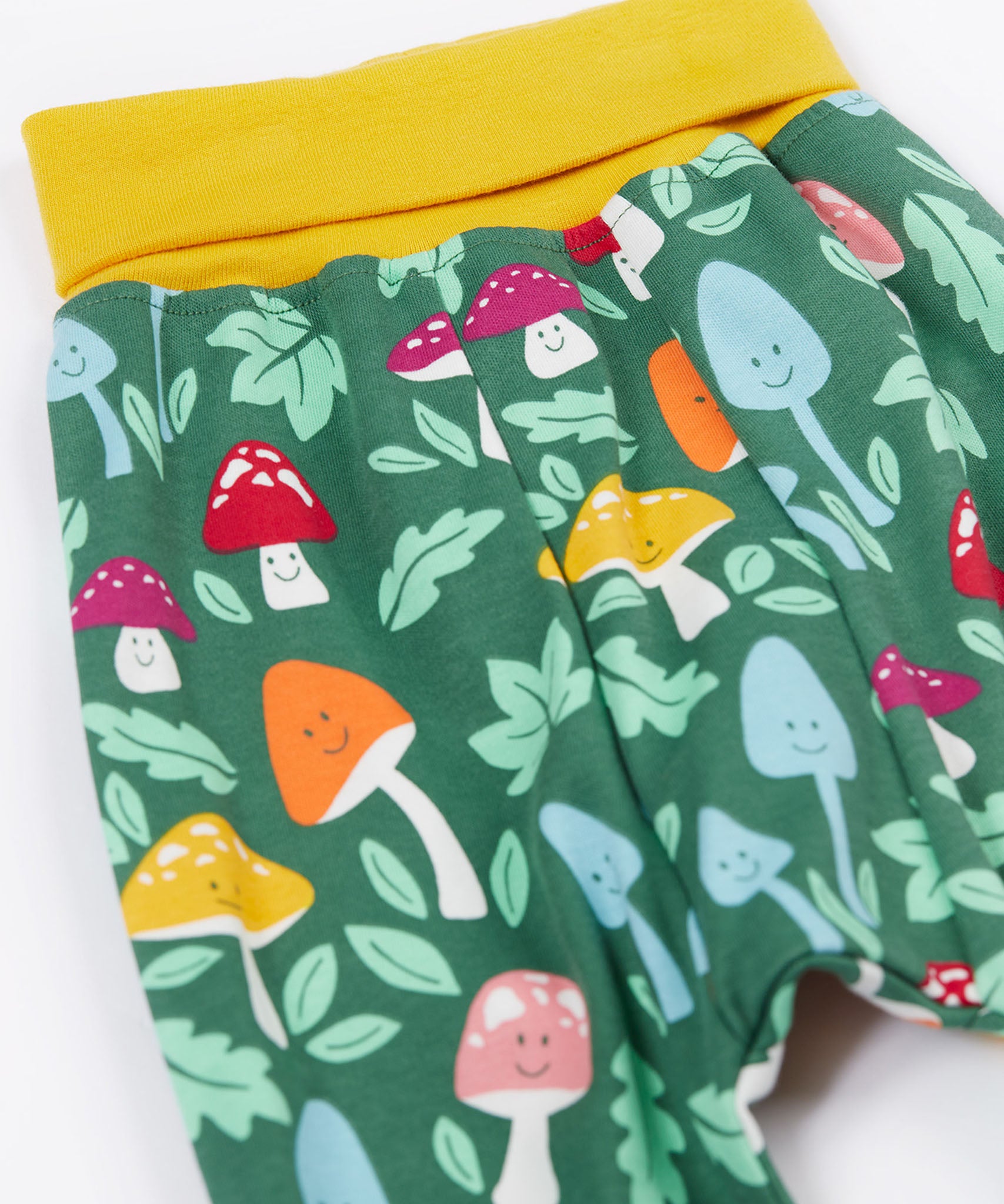 A close up of the mushroom themed print on the Frugi fun guys parsnip pants.
