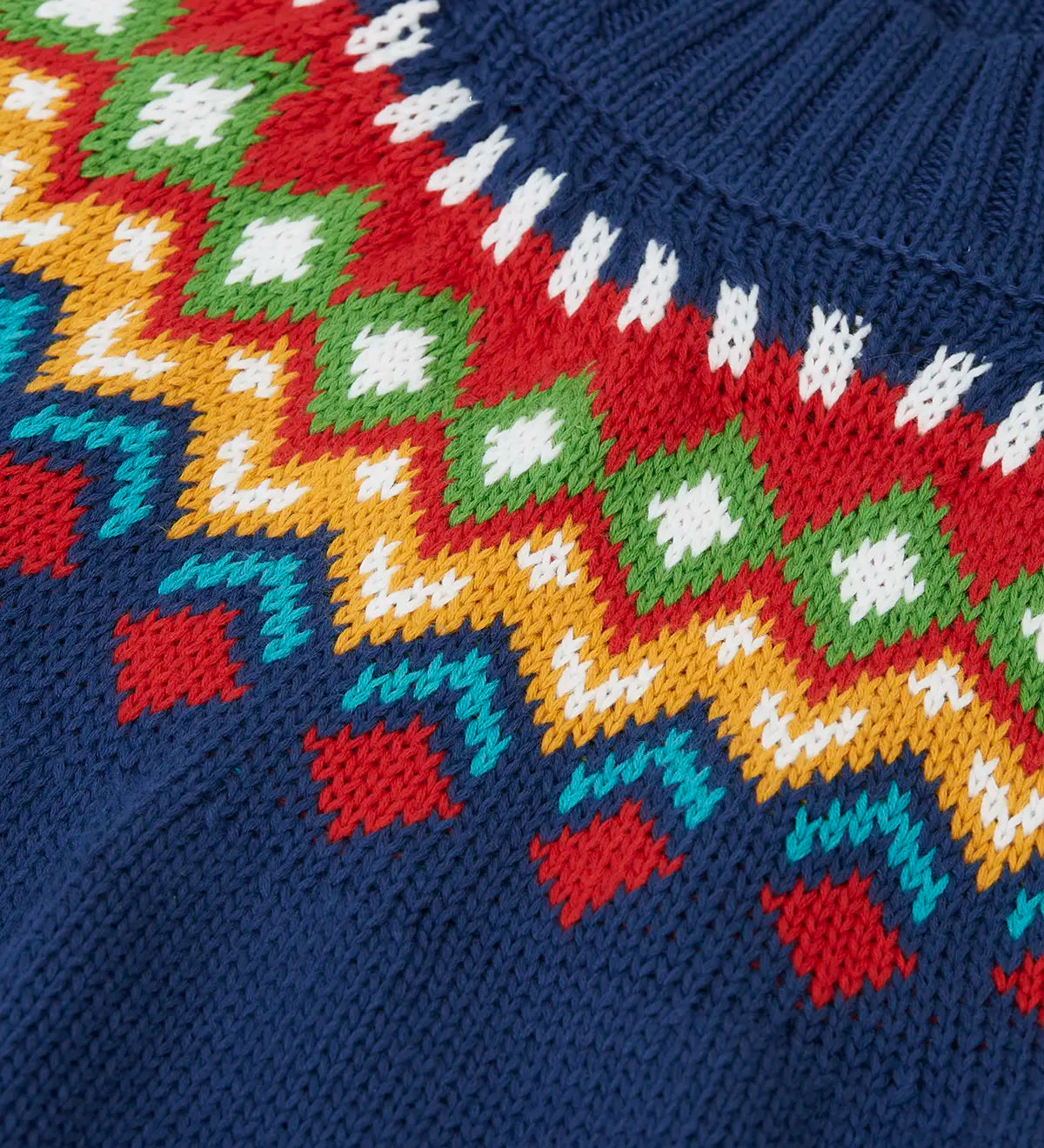 Close up of the fair isle details along the neckline of the Frugi fyfe knitted jumper in navy.