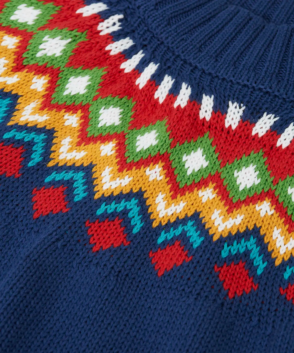 Close up of the fair isle details along the neckline of the Frugi fyfe knitted jumper in navy.