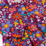 A close up of the Frugi Organic Cotton Chloe Corduroy Dress for Babies and Toddlers featuring a Retro Floral print design. This dress is a part of a wide range of organic cotton clothing for children available here at Babipur.