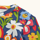 Close up of the popper closure on the shoulder of the Frugi goldie long sleeve organic cotton top in navy with an all over beautiful bunch flowers print.