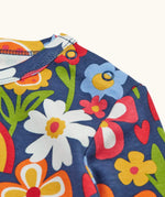 Close up of the popper closure on the shoulder of the Frugi goldie long sleeve organic cotton top in navy with an all over beautiful bunch flowers print.