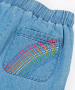 Frugi GOTS organic cotton denim trousers showing close up of a rainbow embroidery design on the back pocket and elasticated waist band