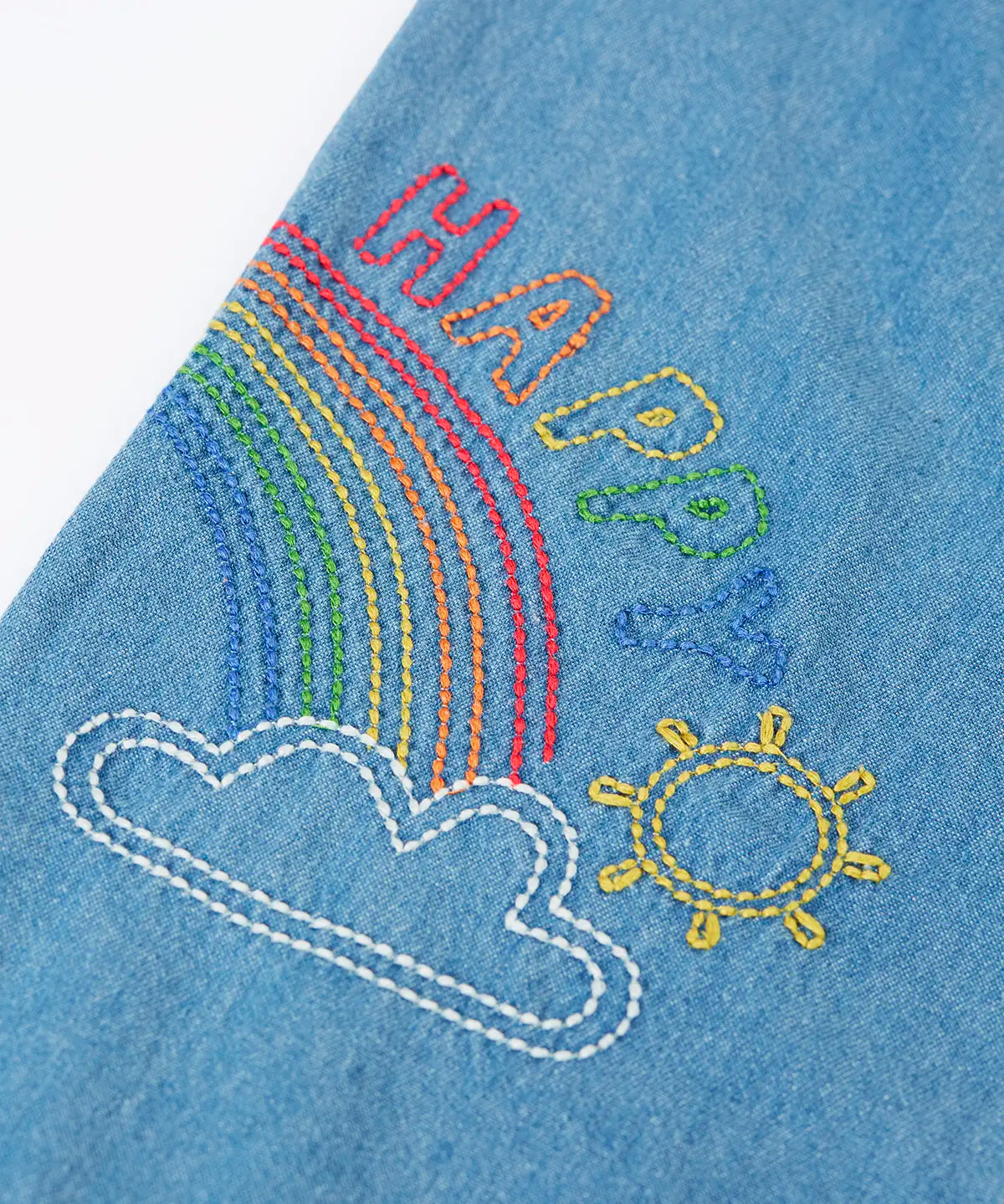 Frugi GOTS organic cotton denim trousers showing close up of a rainbow embroidery design on the leg