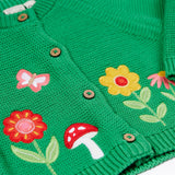A close up of the flower, butterfly and mushroom appliques on the front of the Frugi colby clover green coloured knitted organic cotton cardigan.