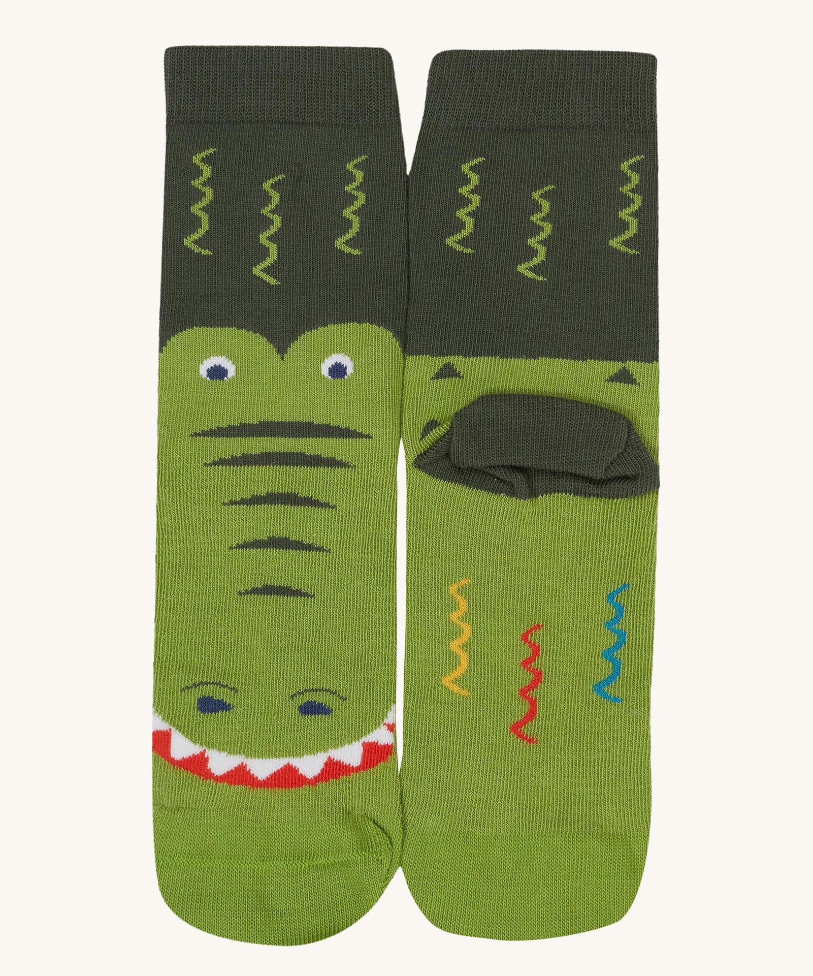 A close up of the Frugi green crocodile sock a soft GOTS cotton sock features a dark green sole panel
