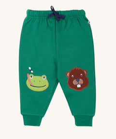 Frugi holly green coloured frog beaver crawlers kids organic cotton joggers. One knee has a frog applique the other knee has a beaver.