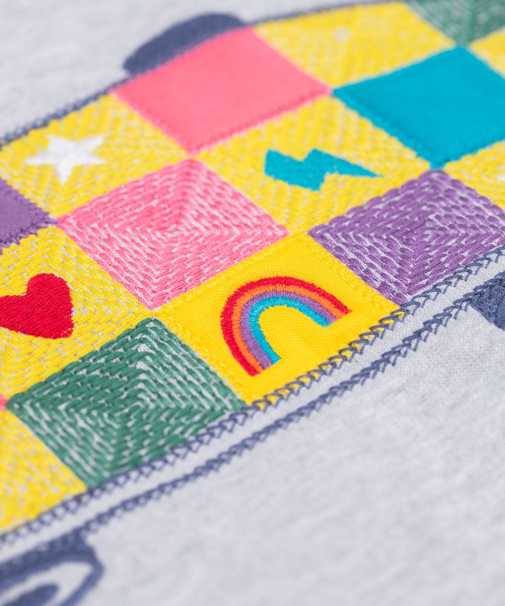 A close up of the embroidered skatebaord design on the front of the Frugi Superb Stitched Skateboard sweatshirt. 