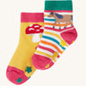 Frugi kids organic cotton grippy socks featuring wild woods designs.  One pair is rainbow striped with a horse and yellow flower grips. The other pair features a mushroom design with green flower grips, one sock is yellow one is pink.