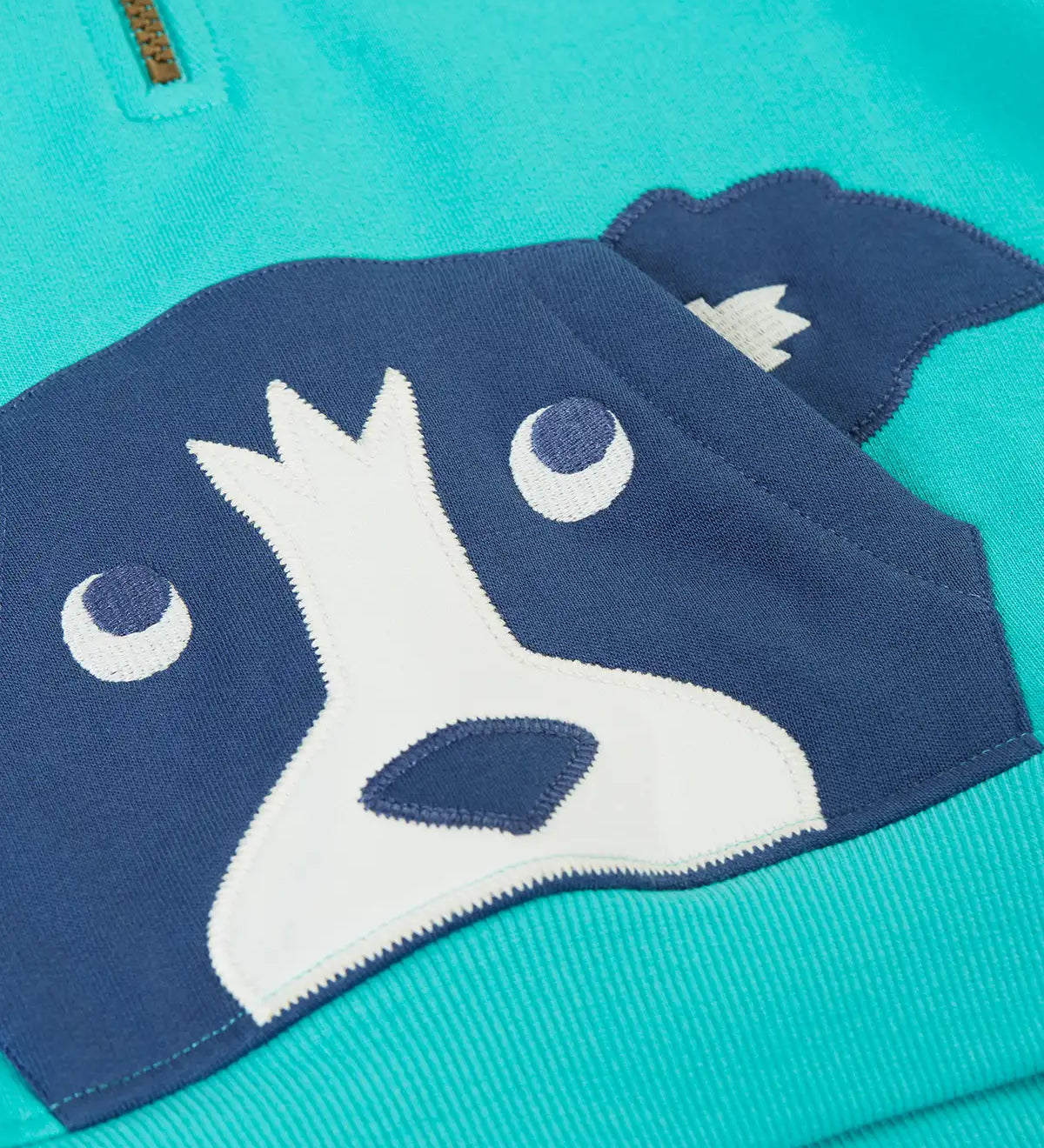 A close up of the dog applique kangaroo pocket on the front of the Frugi hadley dog blue kids hoodie.