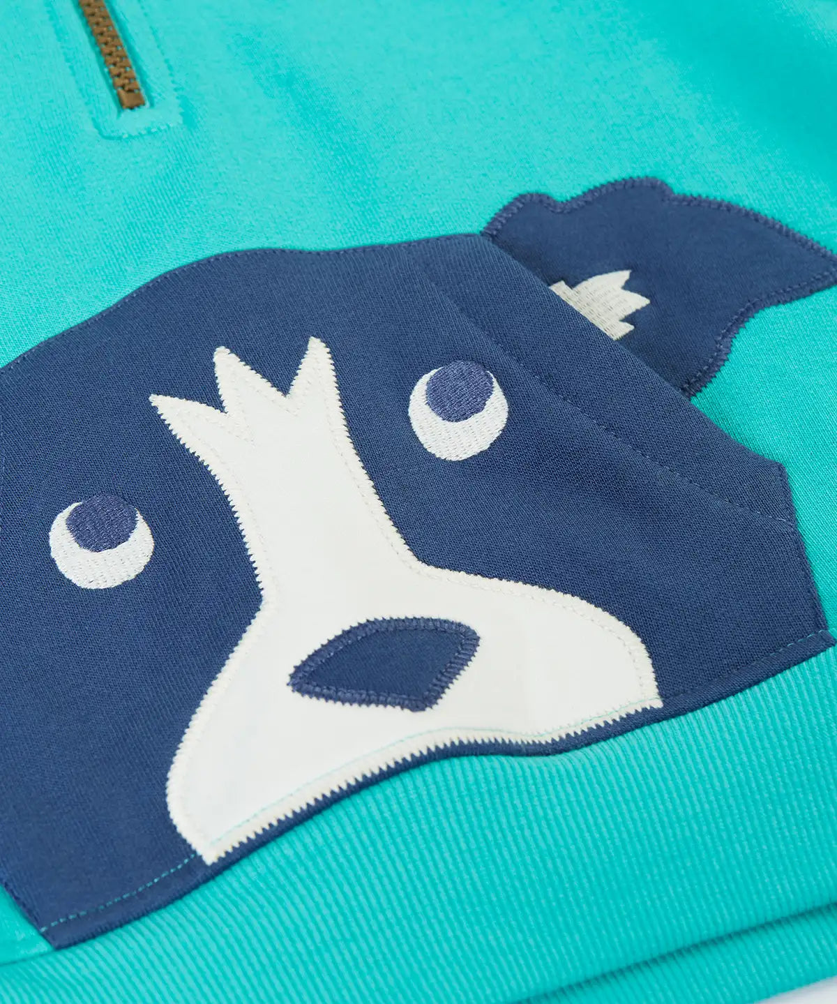 A close up of the dog applique kangaroo pocket on the front of the Frugi hadley dog blue kids hoodie.
