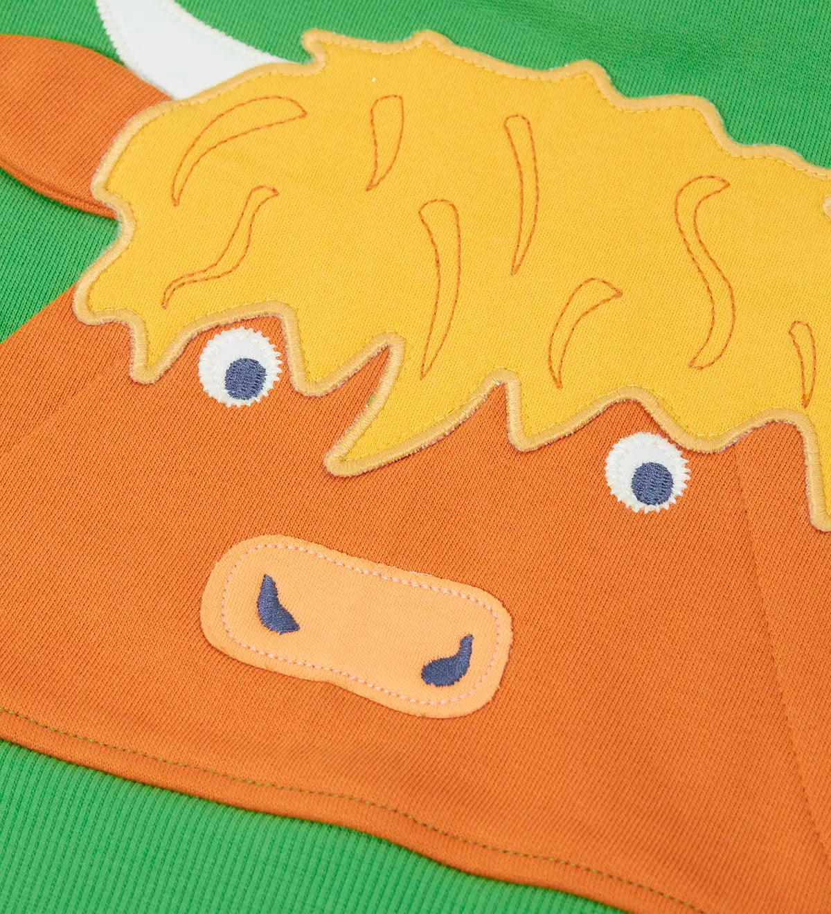 Close up of the Highland cow kangaroo pocket on the front of the Frugi Hadley half zip hoodie in palm green.
