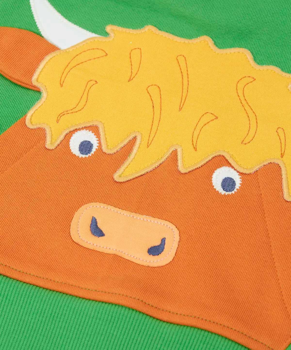 Close up of the Highland cow kangaroo pocket on the front of the Frugi Hadley half zip hoodie in palm green.