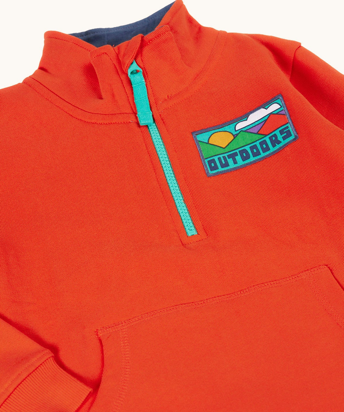 A close up of the front of the Frugi Half Zip Organic Cotton Papaya orange Jumper with large Outdoors colour block style graphic.