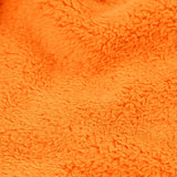 Close up of the orange recycled polyester fleece on the Frugi Helston reversible hoodie jacket. One side is navy cotton with a hello badge design on the chest  with a orange fleece body and yellow sleeves on the other.