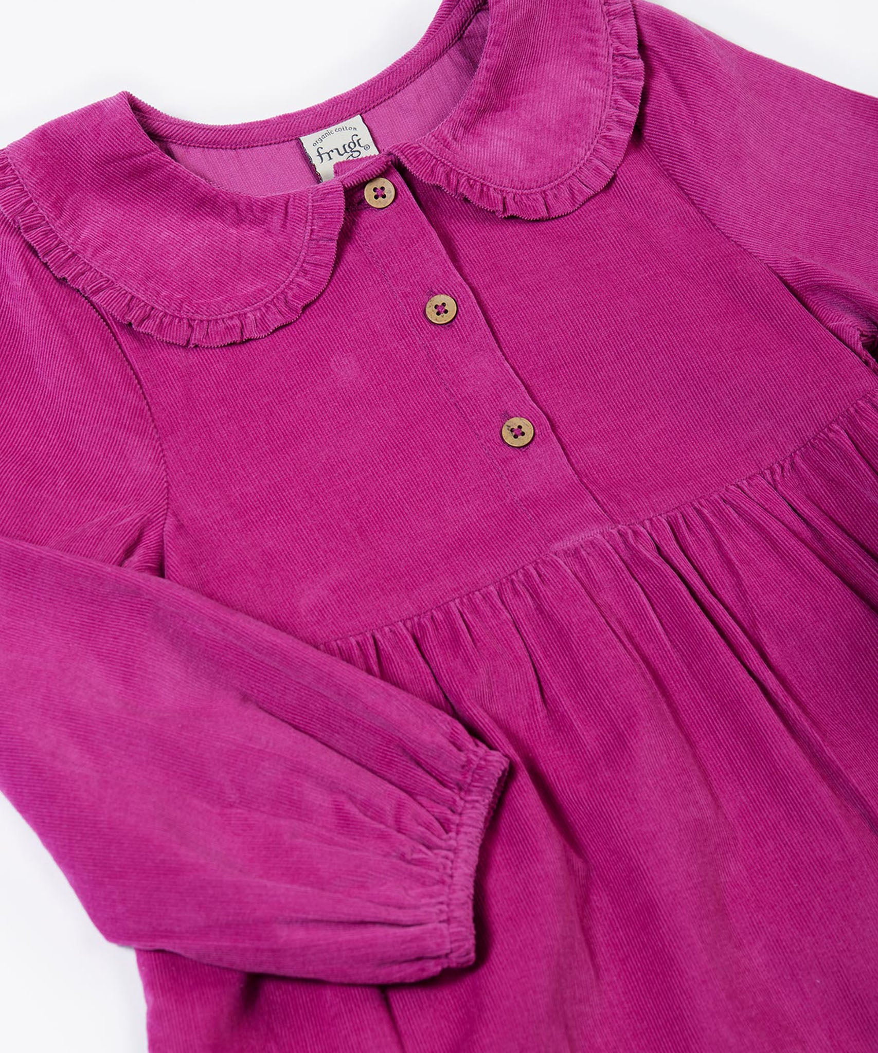 A close up of the Frugi kids holly dress in damson flowers showing the corduroy and frilled collar detail with button fasteners on bright purple organic cotton fabric.