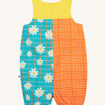 Frugi Summer Printed Dungaree in the Rainbow Hotchpotch print laid flat, showing a patchwork type design in yellow, orange and blue with daisies.
