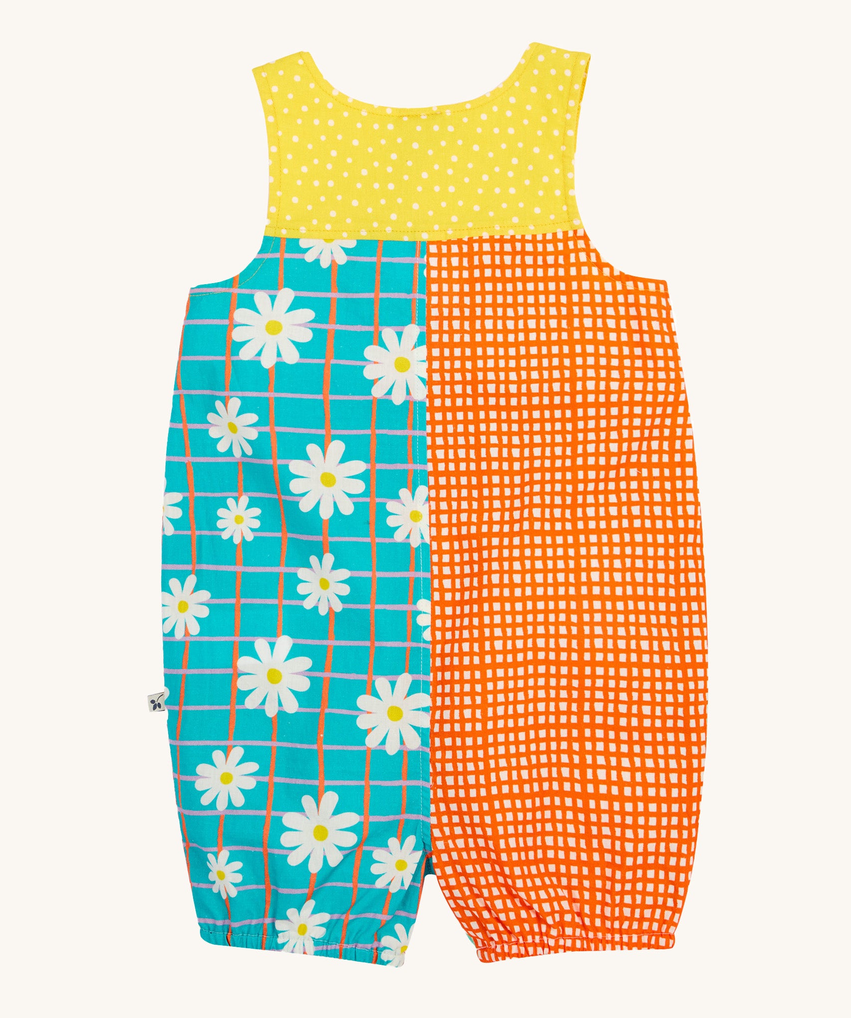 Frugi Summer Printed Dungaree in the Rainbow Hotchpotch print laid flat, showing a patchwork type design in yellow, orange and blue with daisies.