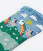 Close up on the Frugi kids hygge knee high sock showing horse in a field of daisies design on organic cotton fabric