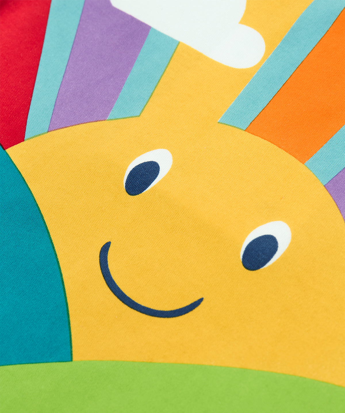 A close up of the yellow smiley sunshine graphic on the front of the Frugi organic cotton lichen green t-shirt.
